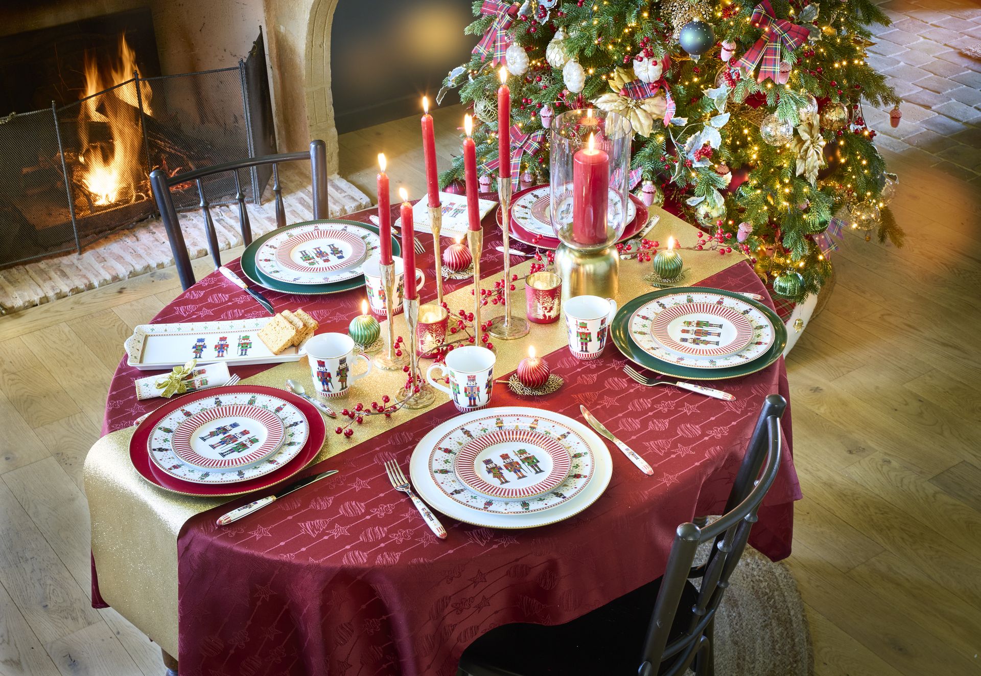 Table de Noël dressée avec nappe rouge, bougies et vaisselle festive