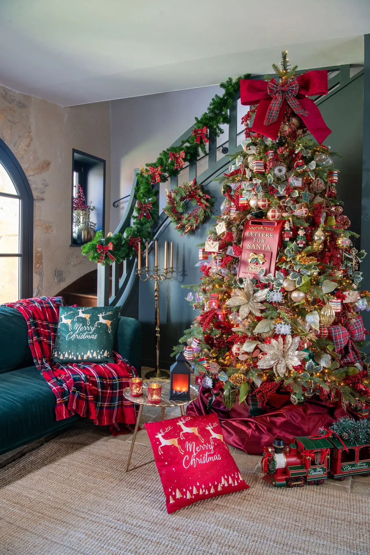 Ambiance Noël d’antan : sapin rouge, or et tartan dans un salon vert profond