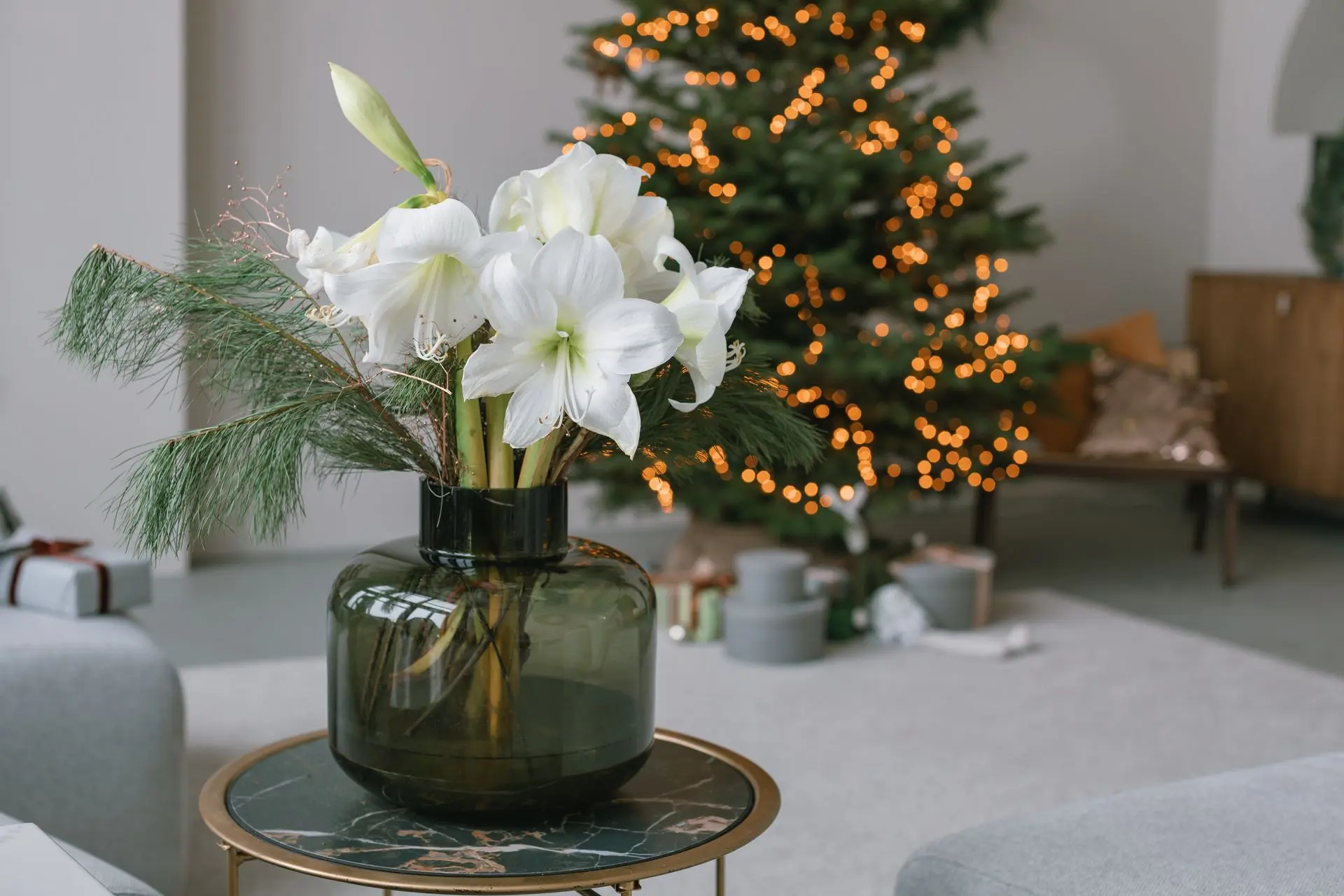 Bouquet de fleurs blanches dans un vase devant un sapin illuminé
