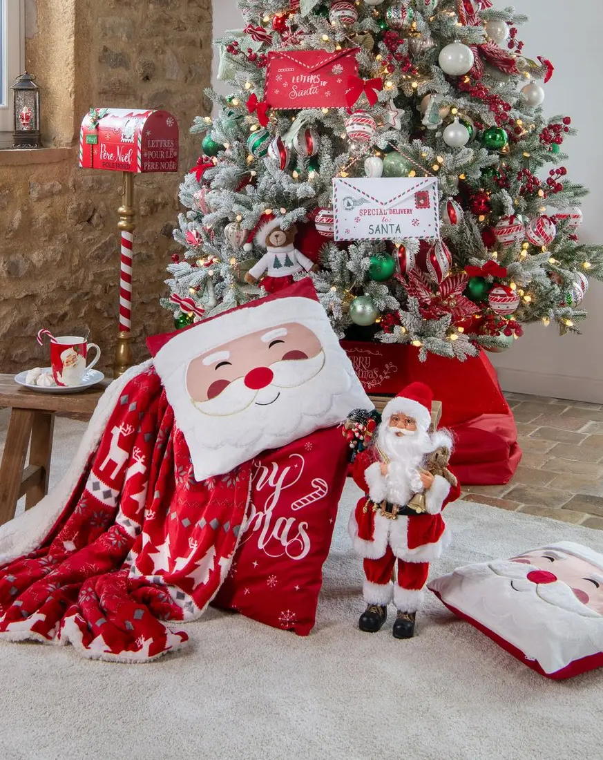 Sapin blanc et rouge décoré façon Père Noël, coussins Merry Christmas, lanternes rouges et boîte aux lettres