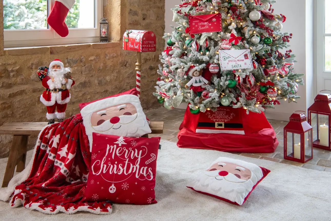 Ambiance Noël traditionnel : sapin rouge et blanc, plaid et coussins Père Noël