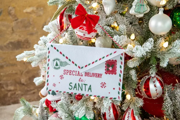 Enveloppe « Special delivery to Santa » accrochée dans un sapin enneigé