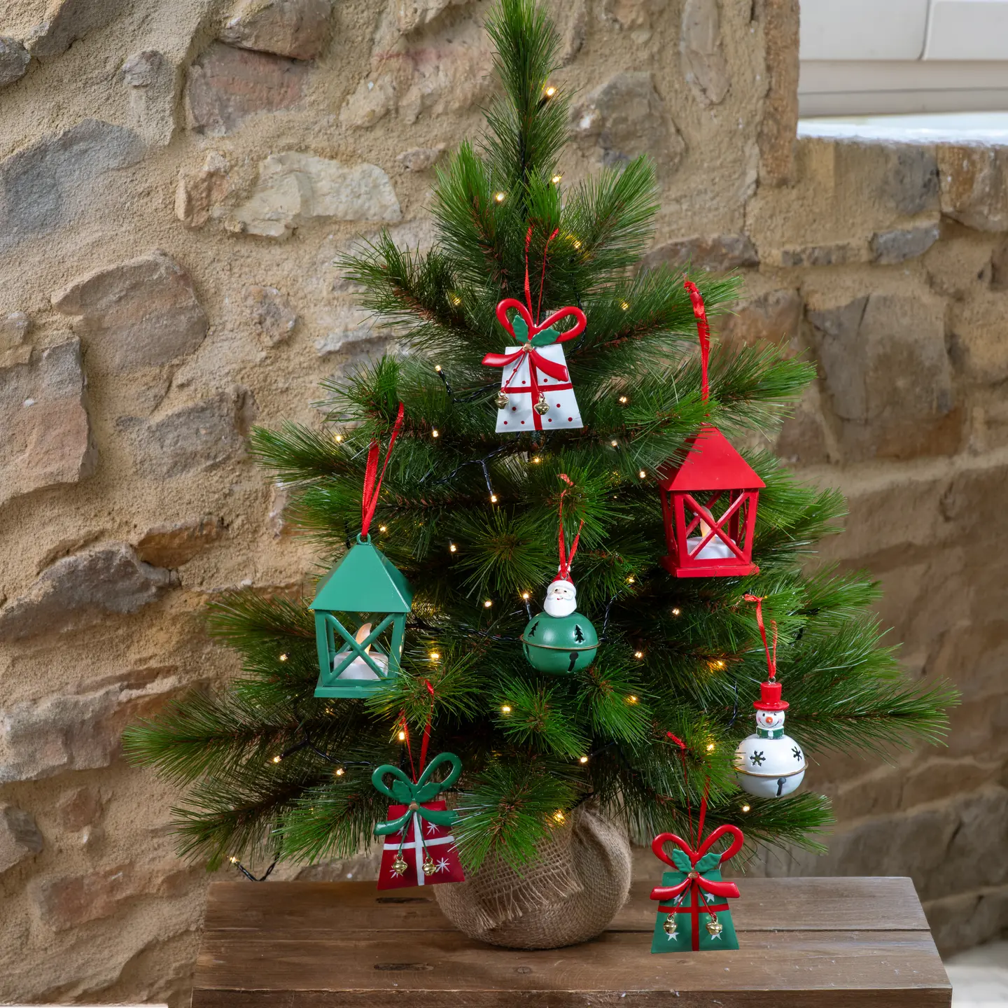 Petit sapin décoré de lanternes et de paquets rouges et verts